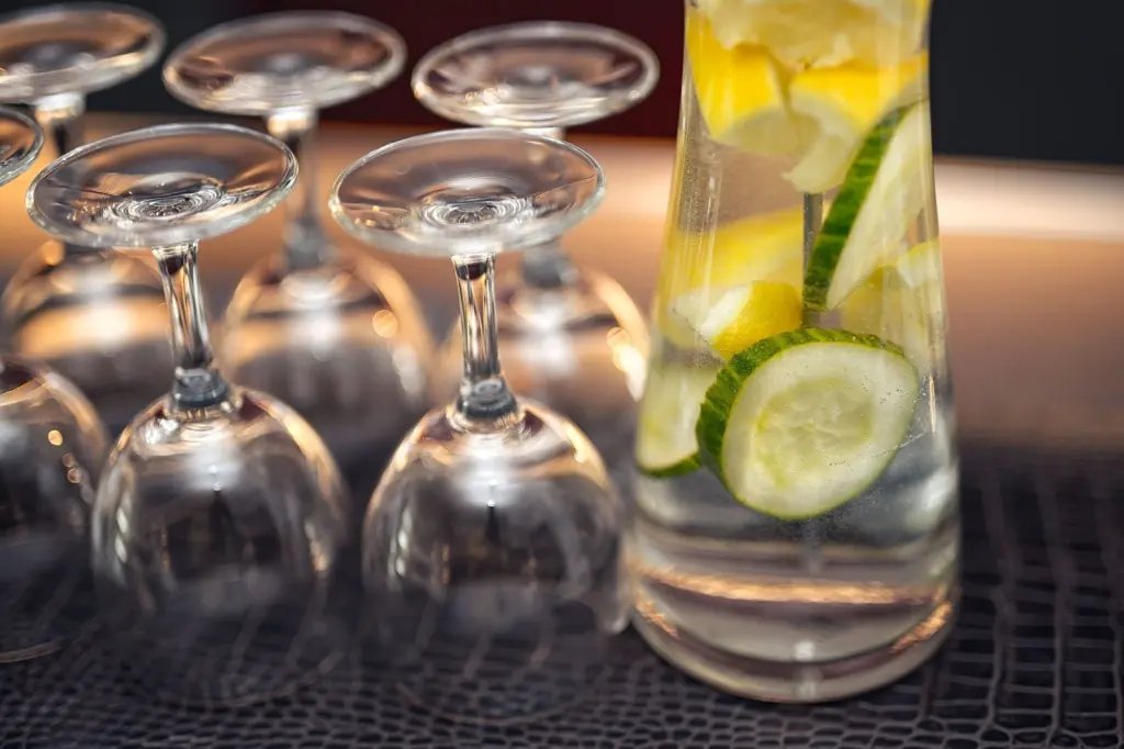 Gläser und frisches Wasser mit Gurke und Zitrone